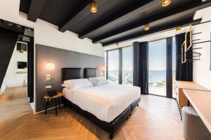 a bedroom with a large bed with a view of the ocean at MaisonMe Boutique Hotel in Bardolino