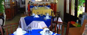 a table with a blue table cloth and a yellow table with chairs at Hotel Pousada do Comendador in Guarujá