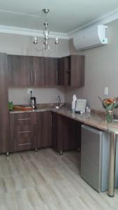 a kitchen with wooden cabinets and a counter top at hanna's place in Polokwane