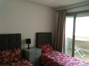 a bedroom with a bed and a dresser and a window at Prestigia PDN in Sidi Bouqnadel