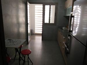 a small kitchen with a small table and a window at Prestigia PDN in Sidi Bouqnadel