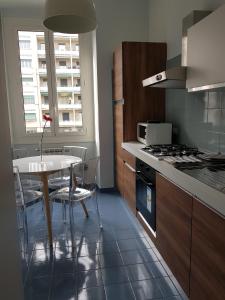 eine Küche mit einem Tisch und einem Herd Top-Backofen in der Unterkunft apartment genova central in Genua