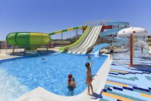 einen Wasserpark mit Rutsche und Menschen im Wasser in der Unterkunft Aegean Blue Villa's - All Inclusive & Water park in Kalathos