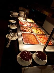 a buffet line with many trays of food and sauce at Carousel Hotel in Blackpool