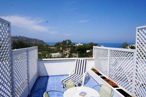 a balcony with chairs and tables and the ocean at Bristol Hotel in Ischia