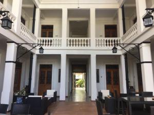 a hallway of a white building with tables and chairs at Casa Meba Hotel Boutique in Tampico