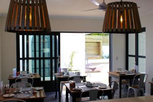 a dining room with tables and chairs and large windows at Whale Rock Luxury Lodge in Hermanus