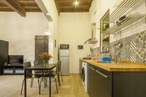 una cucina con lavandino e tavolo con sedie di Capponi Suite a Firenze