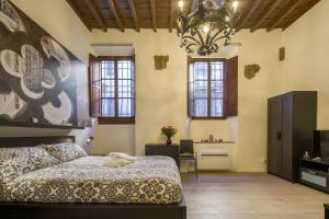 una camera con letto e lampadario a braccio di Capponi Suite a Firenze