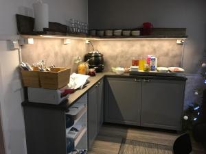 a kitchen with a stove, sink, and cabinets at Guesthouse Borealis in Rovaniemi