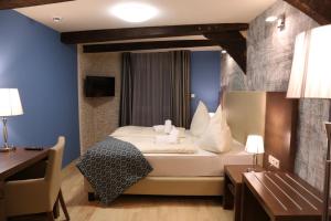 a hotel room with a bed and a desk at Markthotel Warendorf in Warendorf +6 photos