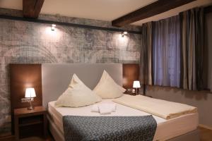 a bedroom with a bed with white sheets and pillows at Markthotel Warendorf in Warendorf