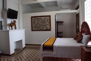 um quarto com uma cama e uma televisão na parede em Casa Meba Hotel Boutique em Tampico