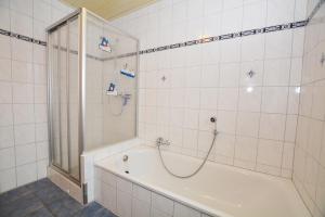 a bathroom with a shower and a bath tub at Haus Sonja in Büsum +24 photos