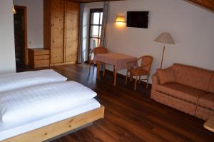 a bedroom with a bed and a couch and a table at Hotel Eden Guesthouse in Marlengo