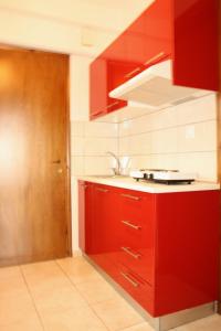 a kitchen with red cabinets and a sink at Maira Luxury Studios in Litochoro
