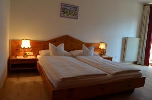 a bedroom with a large bed with two lamps at Hotel Eden Guesthouse in Marlengo +5 photos