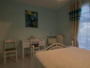 a bedroom with a bed and a table and a chair at Les Rendzines in Nuisement-sur-Coole