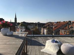 Un balcón con copas de vino y vista a una ciudad. en Nauwieser50, en Saarbrücken