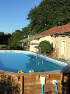 a swimming pool with two balls and a house at The little house in Mézières-sur-Issoire
