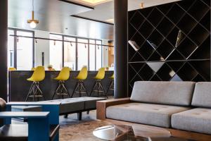 a living room with a couch and yellow chairs at MaisonMe Boutique Hotel in Bardolino