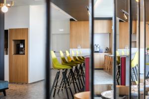 a bar with yellow chairs in a restaurant at MaisonMe Boutique Hotel in Bardolino