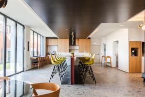 a kitchen with a bar with yellow stools at MaisonMe Boutique Hotel in Bardolino