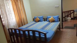 a bedroom with a bed with blue sheets and pillows at Birds Nest Home Stay in Cochin