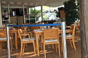 un restaurante con mesas y sillas de madera y una barra azul en SkySea Holidays MI CAPRICHO en Sitio de Calahonda