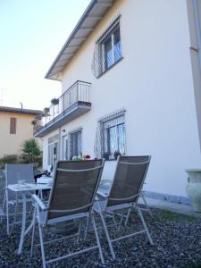 un groupe de chaises et une table devant une maison dans l'établissement IL CILIEGIO Affittacamere, à Stresa