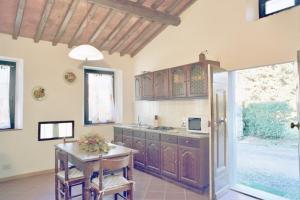a large kitchen with wooden cabinets and a table at Agriturismo Il Palazzaccio in Galliano