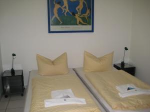 2 camas en una habitación con una foto en la pared en Villa Caprivi - Ferienwohnung 5 en Heringsdorf