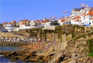 un grupo de personas de pie en un acantilado cerca del agua en Ericeira T2 Navegantes Apartment, en Ericeira