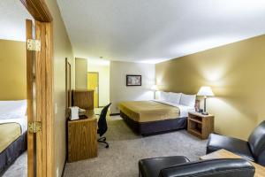 um quarto de hotel com uma cama e uma cadeira em Econo Lodge - Valley City em Valley City