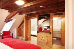 a bedroom with wooden ceilings and a red bed at Logis Hôtel Ettenheim in Strasbourg