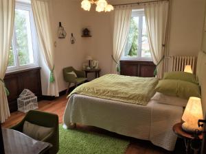 - une chambre avec un lit, une chaise et des fenêtres dans l'établissement La Maison du Parc, à Yzeron