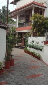 une cour d'un bâtiment avec des plantes en pot dans l'établissement Birds Nest Home Stay, à Cochin