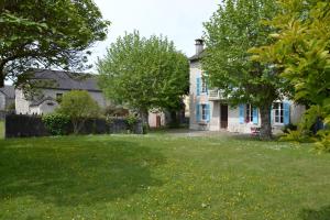 a white house with a yard with trees and grass at L'Estancat in Pardies-Piétat