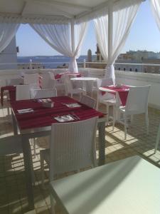 un ristorante con tavoli bianchi e sedie bianche con vista di Hotel Città Bella a Gallipoli