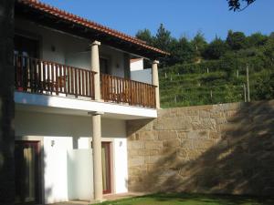 a building with a balcony with a dog sitting on it at Hotel Rural Quinta de Novais in Arouca