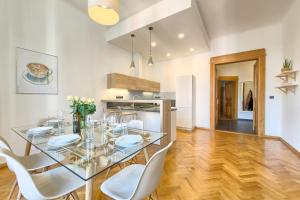 comedor con mesa de cristal y sillas blancas en Spacious And Bright Apartment Dusni 13 en Praga