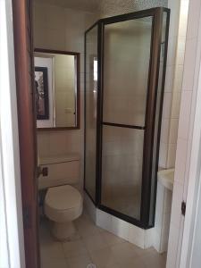 uma casa de banho com um WC e uma cabina de duche em vidro. em Room and private Bathroom at Chapinero Alto em Bogotá