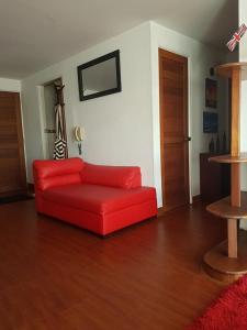um sofá vermelho sentado numa sala de estar em Room and private Bathroom at Chapinero Alto em Bogotá