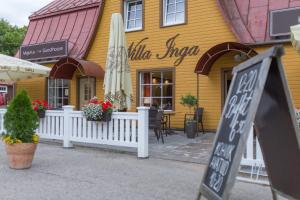 un edificio amarillo con sombrilla y un restaurante en Willa Inga, en Leisi