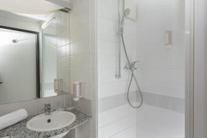 
a bathroom with a shower, sink, and mirror at ibis Styles Hotel Gelsenkirchen in Gelsenkirchen

