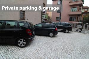 two cars parked in a parking lot next to a building at Le Petit Prince Guesthouse Free Gated Parking in Sarajevo