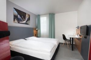 Habitación de hotel con cama y escritorio con ordenador en ibis Styles Hotel Gelsenkirchen en Gelsenkirchen