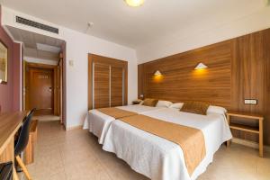 una camera con un grande letto con testiera in legno di Prince Park a Benidorm
