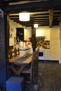a large kitchen with a wooden table and chairs at La Petite Passerelle à Mouzaive in Vresse-sur-Semois