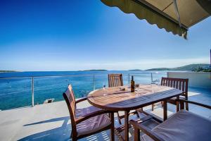 a wooden table on a balcony with a view of the ocean at Seaview Suite Lissa in Vis